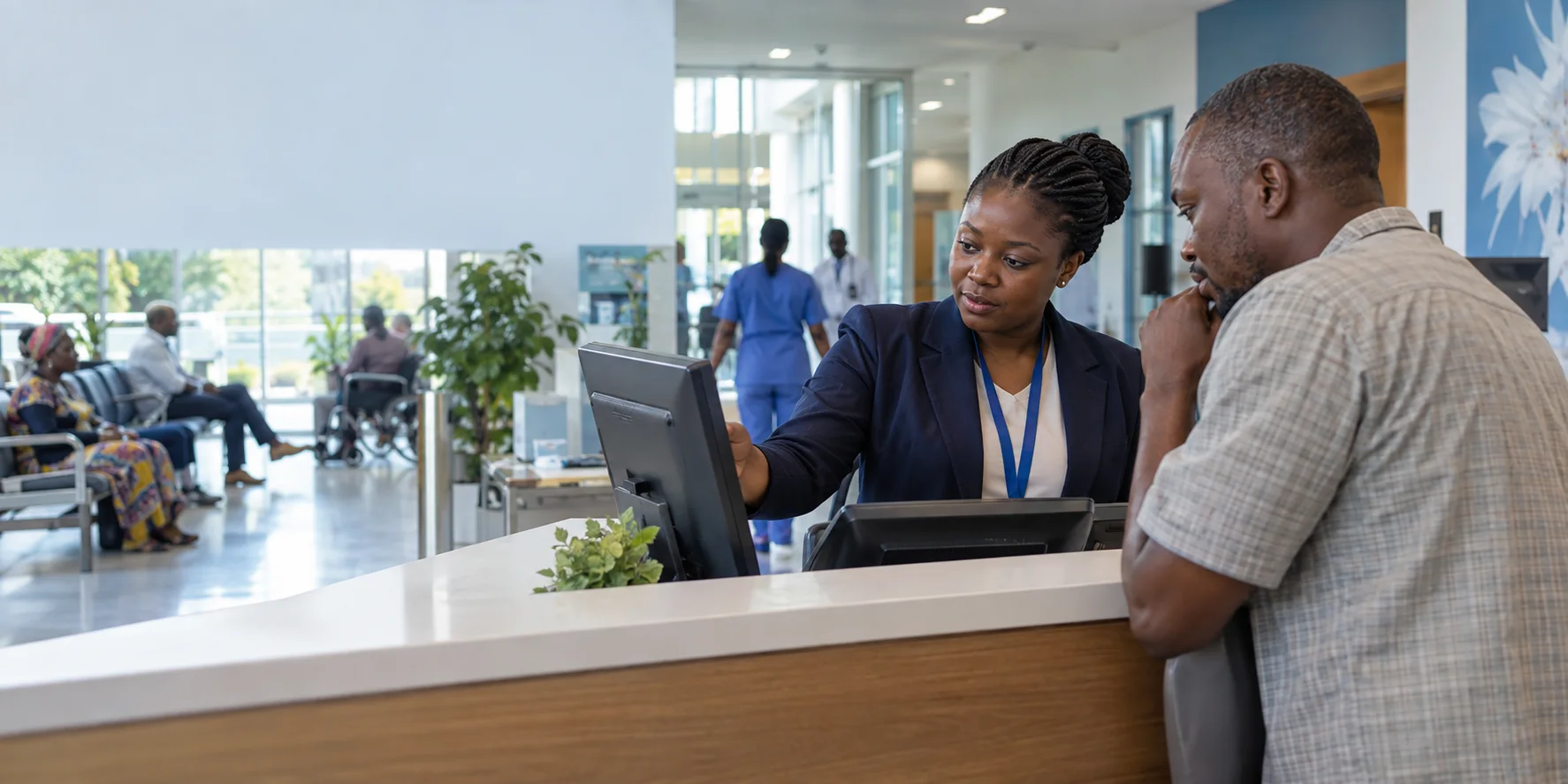 Hospital billing officer assisting a visitor at a reception counter
