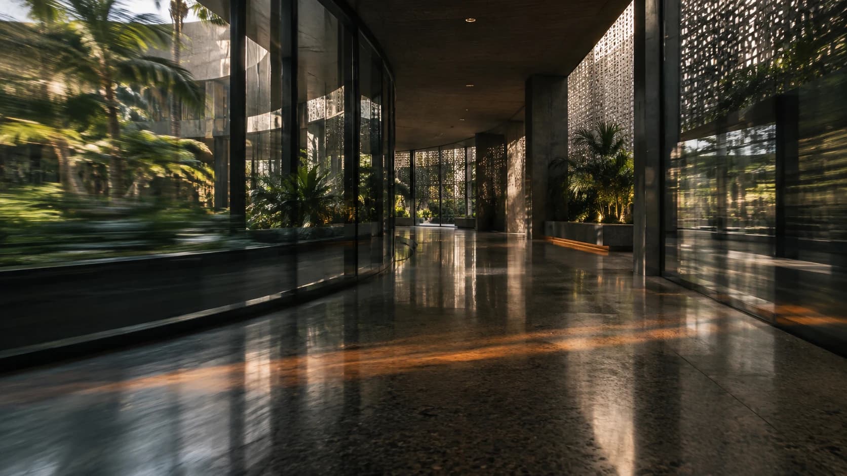 Motion through a shaded hospital passage with tropical courtyard reflections